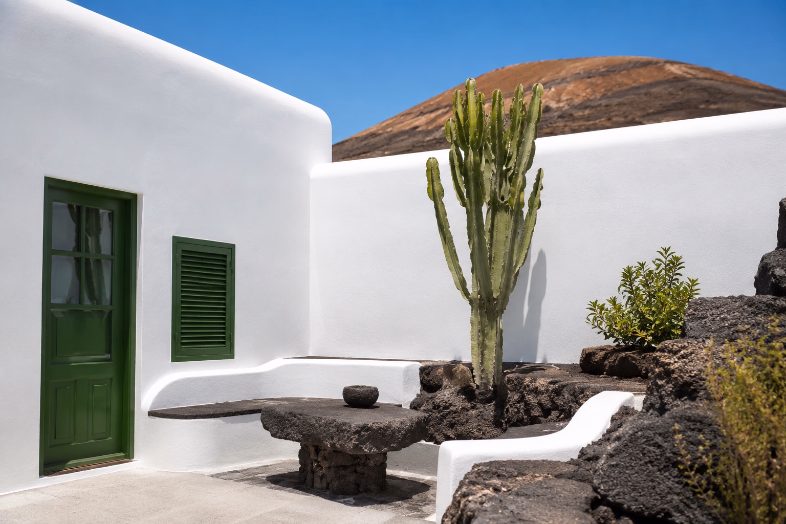 Whitewashed courtyard with volcanic stone and cactus in Lanzarote, shaped by the aesthetic of César Manrique. A private retreat with your male companion.