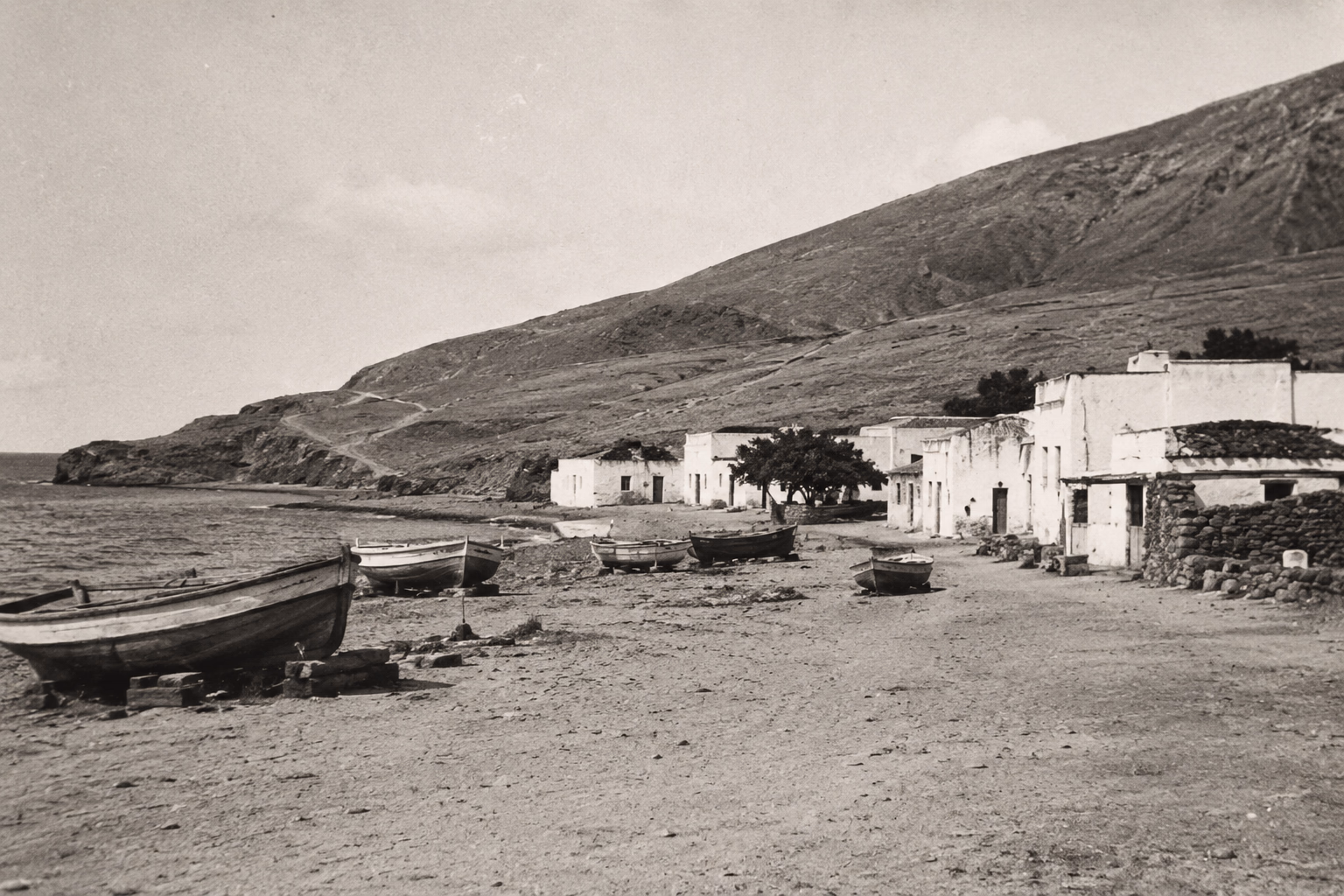 Los Cristianos negli anni Cinquanta: case basse imbiancate, barche in secca sulla sabbia e una collina spoglia dietro, prima che arrivasse il turismo a Tenerife.