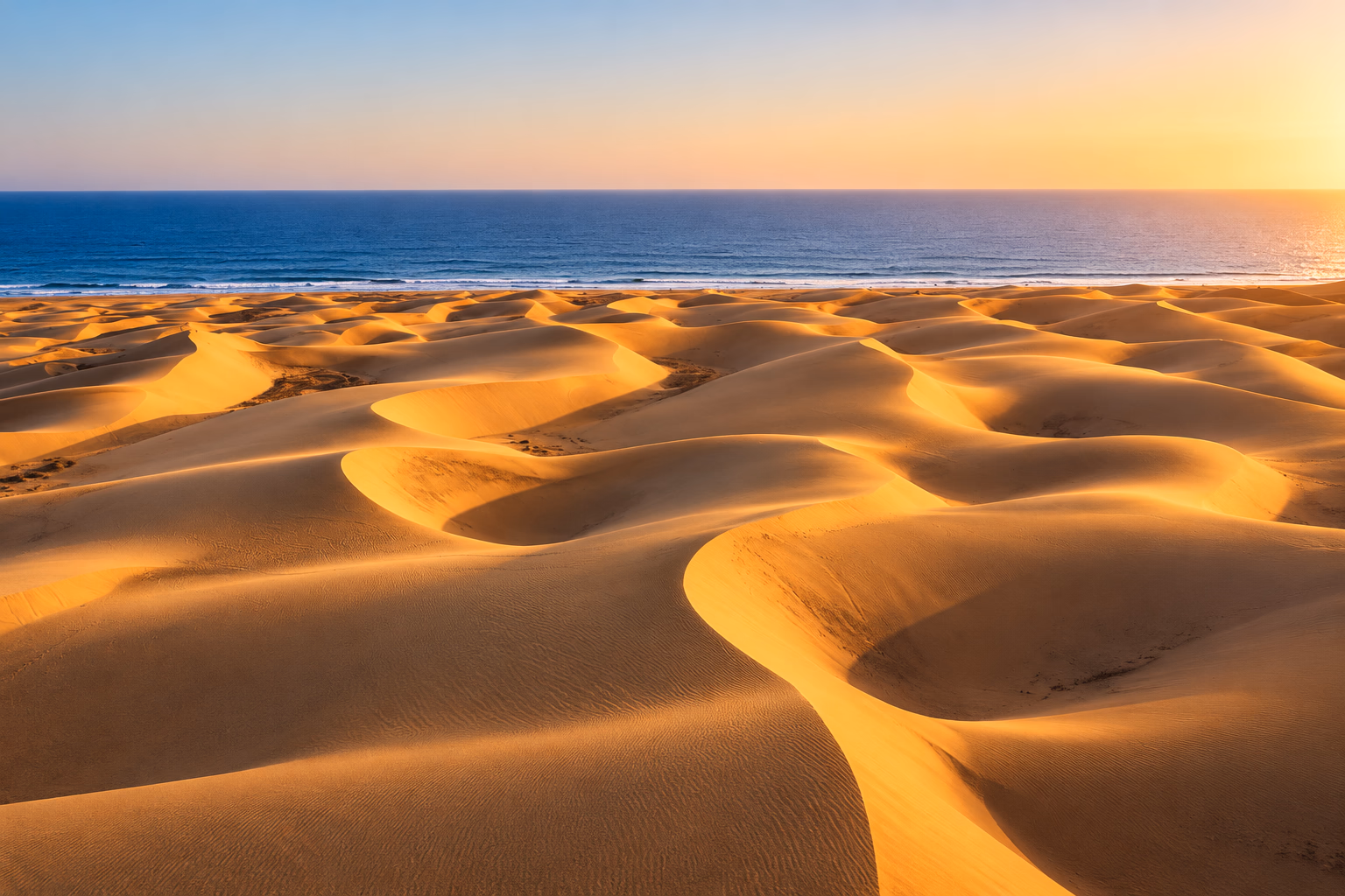 Dune dorate di Maspalomas al tramonto, con l'oceano sullo sfondo