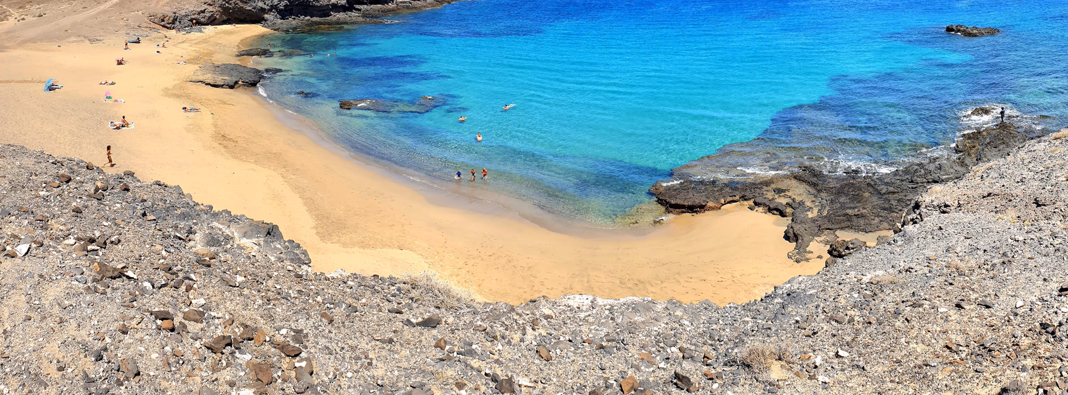 Eine Bucht mit goldenem Sand und türkisem Wasser in Papagayo, von der Steilküste aus gesehen
